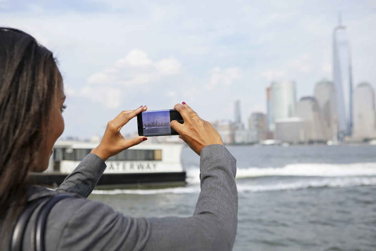 Une femme qui prend des photos du Ferry de Manhattan