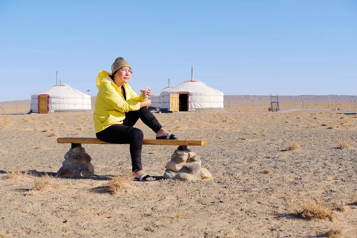 Une femme devant des yourtes Kirghizistan